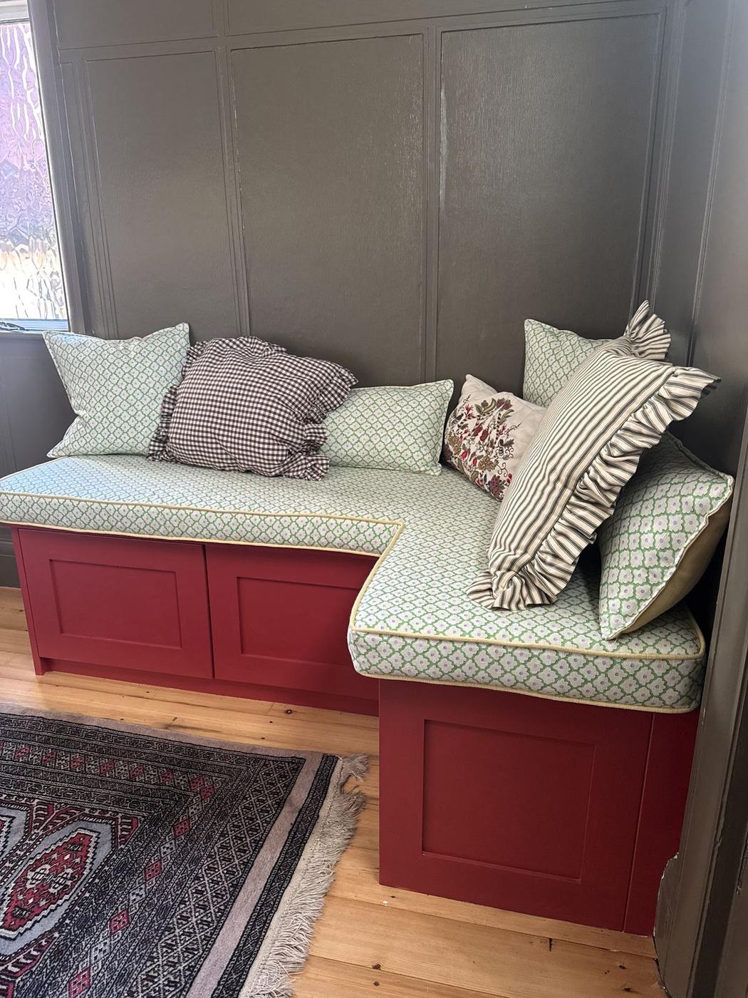 Fitted window seat with striped and patterned cushions in a customer's home