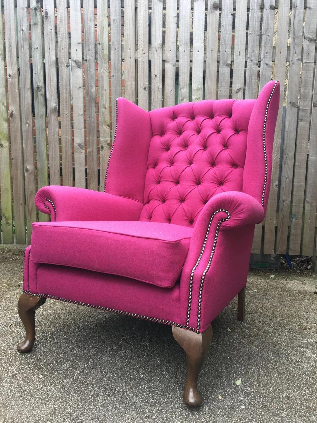 Pink buttoned wing chair with brass studs